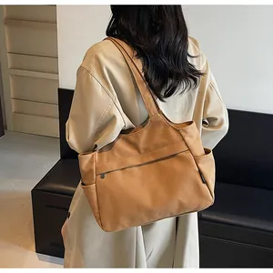 Détail du grand sac cabas marron en nylon avec poches latérales et fermeture éclair