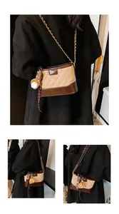 Macro view of quilted bucket bag detail with baseball pendant and brown tassel trim