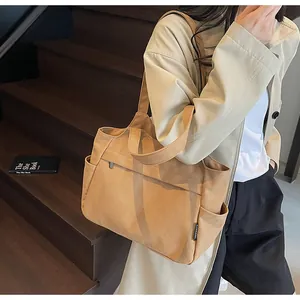 Détail du sac fourre-tout en nylon kaki avec poches latérales et profil spacieux