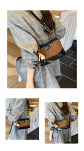 Detail of vintage quilted bucket bag with chain strap and creative baseball charm