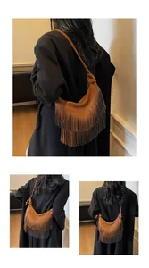Detail van de bruine suède hobo tas met lange franjes en boho houten kraal accenten