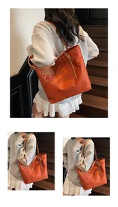 Detail van een oranje nylon draagtas met leren riemen op een casual vrouwelijk model
