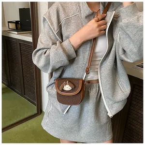 Brown mini crossbody bag with white polka dots and cute puppy detail on female model