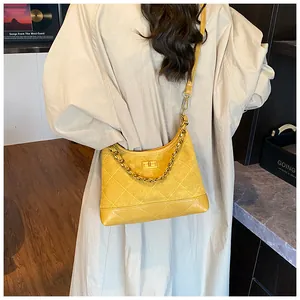 Détail du sac bandoulière jaune matelassé avec fermoir rotatif en métal doré et chaîne