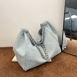 Stylish light blue denim tote bag with silver chain straps and a spacious silhouette