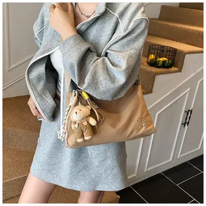 Détail du sac messager en toile kaki avec breloque ours et broderie CHUU D'N élégante