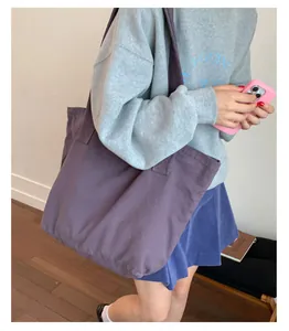 Vue latérale d'un grand sac cabas en toile violette avec de larges bandoulières souples