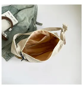 Detail of beige nylon crescent bag interior showing zipper pocket and spacious lining