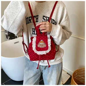 Vue détaillée d'un sac à dos en velours rouge à pois avec broderie d'ours mignonne