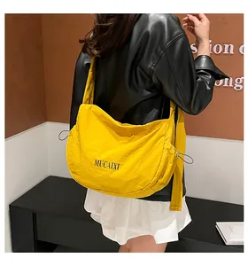 Detailed side view of a large yellow nylon crescent bag showing its capacity and drape