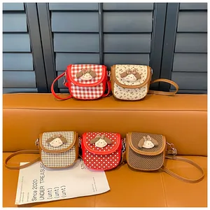 Detailed display of five mini crossbody bags with cute plush doll heads and various patterns