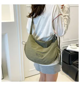Detailed view of green nylon crescent hobo bag with drawstring and MUCAIXI logo