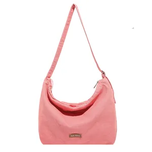 Borsa a tracolla a mezzaluna in tela rosa con tracolla regolabile e patch logo in pelle
