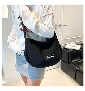 Detail of black nylon crescent bag featuring MUCAIXI letter print and drawstring design