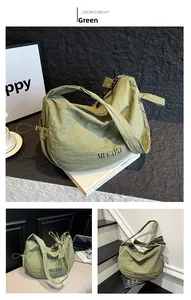Detail view of the green nylon crescent bag showing drawstring shoulder strap and texture