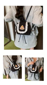 Détail de la broderie chiot et des volants en dentelle blanche sur mini sac à pois noir