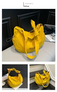 Macro shot of yellow nylon crescent bag featuring side drawstrings and MUCAIX branding