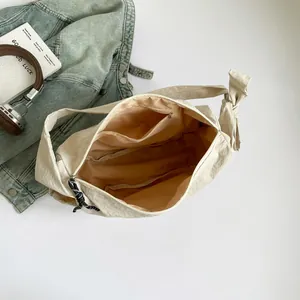 Spacious beige nylon crescent hobo bag with inner pockets and stylish knot strap detail