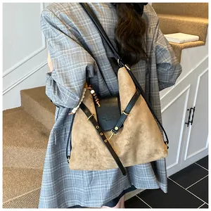 Detail der khakifarbenen Wildleder-Shopper mit schwarzen Lederriemen und Perlenanhänger