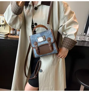 Detail der Retro-Tasche aus Denim und braunem Leder mit Metallschnalle und Griff