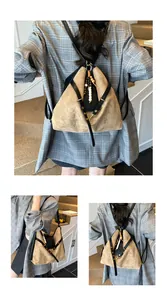 Detail des khakifarbenen Wildleder-Rucksacks mit schwarzen Riemen und Holzquaste