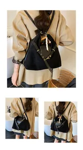 Detail eines schwarzen Wildleder-Rucksacks mit Holzperlen und glatten Lederriemen