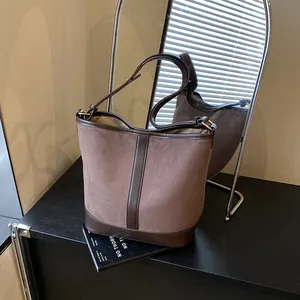 Vintage frosted suede bucket bag with leather strap shown in a creative mirror reflection