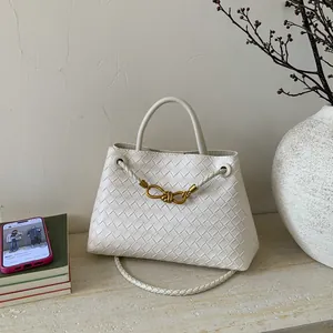 Detailed macro view of white woven leather texture with signature golden knot metal clasp