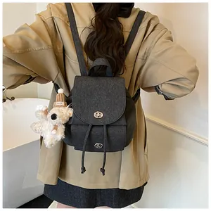 Detailansicht grauer Rucksack mit silbernen Drehverschlüssen und Plüschbär-Anhänger