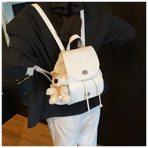 Details des weißen Lederrucksacks mit silbernem Drehverschluss und Bären-Anhänger