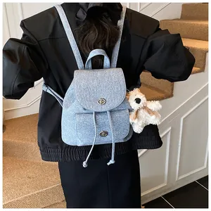 Detail eines hellblauen Rucksacks mit Kordelzug und silbernen Drehverschlüssen