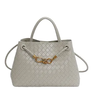Grey woven bucket bag with gold knot buckle and adjustable shoulder strap