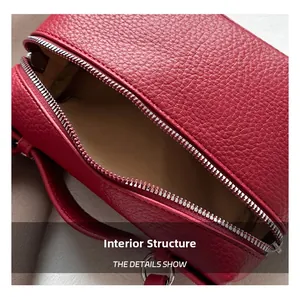 Détail macro du sac en cuir grainé rouge avec fermeture éclair argentée et doublure