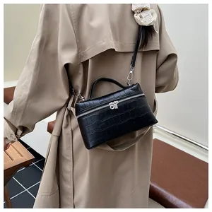 Detail of black faux crocodile leather handbag with silver double zippers and sturdy handle