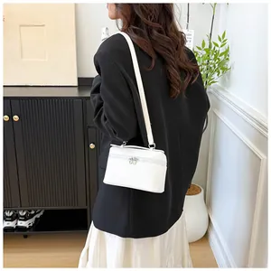 Vue détaillée du mini sac bandoulière blanc en cuir texturé avec fermetures argentées