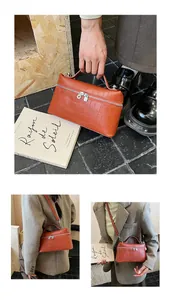 Detail of orange-brown croc-embossed handbag with dual zippers and handle