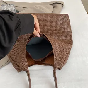 Brown woven leather bucket bag for women with interior zipper pocket and spacious design