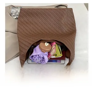 Top view of the brown woven bucket bag showing its large interior capacity with personal items
