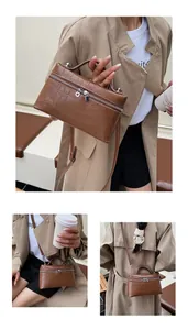 Detailed views of a brown crocodile pattern handbag showing dual-way metal zippers and texture