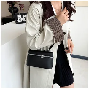 Détail d'un sac bandoulière en cuir grainé noir avec fermeture éclair en argent