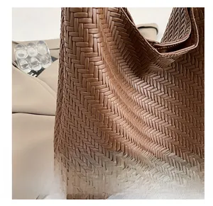 Close-up of brown woven leather texture on bucket bag with matte finish and fine craft