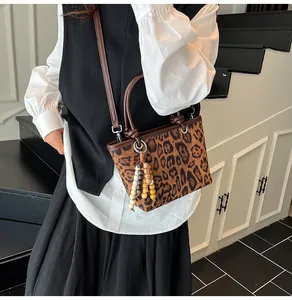 Detailed shot of leopard print bucket bag with colorful bead tassel and brown strap