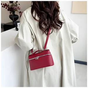 Détail du petit sac carré en cuir rouge avec fermeture éclair argentée et bandoulière