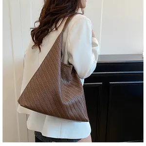 Detailed close-up of dark brown woven leather hobo bag showing V-shaped textured pattern