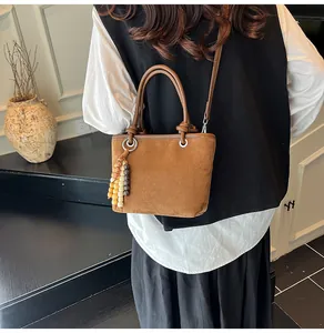 Brown frosted leather tote bag with unique knot handle and colorful beaded tassel detail