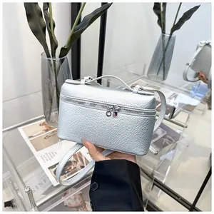 Détail d'un petit sac carré argenté avec texture grainée et poignée supérieure chic