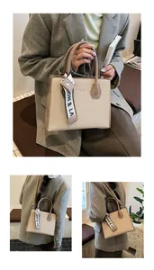 Detail of beige textured fabric tote with brown leather handles and decorative silk ribbon