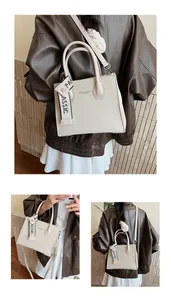 Detail of beige square handbag featuring woven texture and fashion letter branding