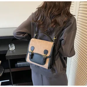 Retro brown suede and black leather backpack shown in a stylish back-carry view on model