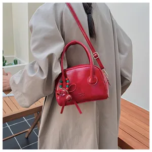 Sac oreiller rouge brillant chic avec poignée incurvée et pendentif noeud décoratif